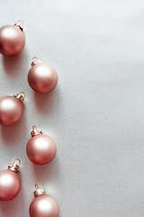 Modern glass Christmas pink balls on shiny silver background with copy space, above. New Year...