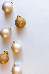 Modern glass Christmas golden minimalist balls on shiny silver background with copy space, above. New Year decor, vertical format