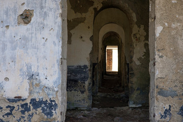 Fototapeta na wymiar Corridors inside a large dilapidated military barracks in the Italian Alps