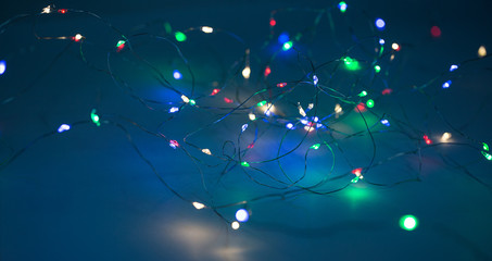 Christmas lights on dark blue background with copy space. Decorative garland