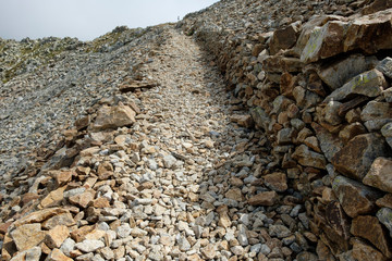 a wide footpath away from loose gravel leads steeply up a slope