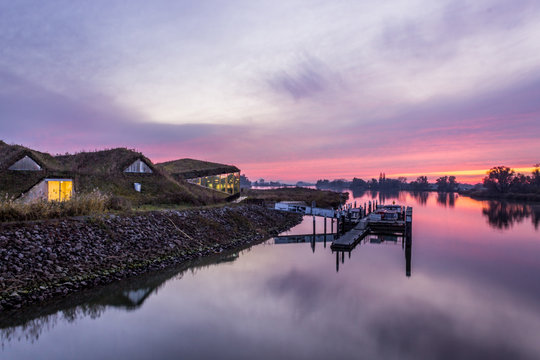 Sunset at the Biesbosch Visitor Centre in autumn season with the water reflecting the colors of the sky.