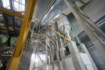 Large industrial mixer, for mixing ingredients into liquid cement.. Workers in the workshop of the House-building plant. Industrial interior. Concrete plant.