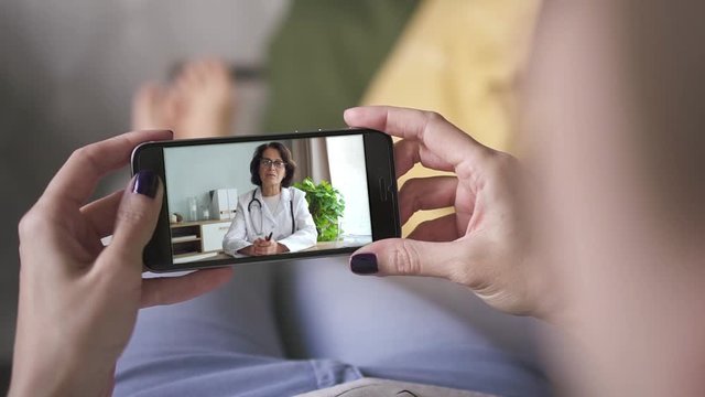 woman talking to female doctor via smart phone video call. online medical consultation. doctor explaining. ill sick woman listen. concept medicine, healthcare, internet, technology, online.