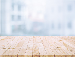 Selective focus of wood table top on white wall glass (big window) background