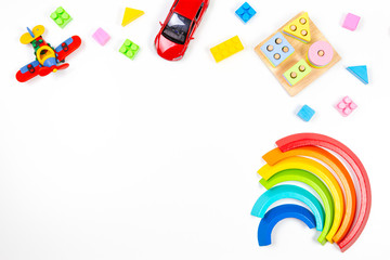 Baby kids toys background. Wooden educational geometric stacking blocks toy, rainbow, airplane, car and colorful blocks on white background. Top view, flat lay