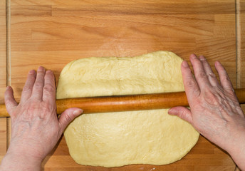 Woman rolling dough for further baking