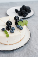 Homemade cheesecake with fresh berries. a piece of cheesecake with a blackberry in the foreground
