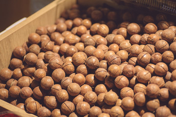 Macadamia nuts on a market counter. Inshell Macadamia Nuts