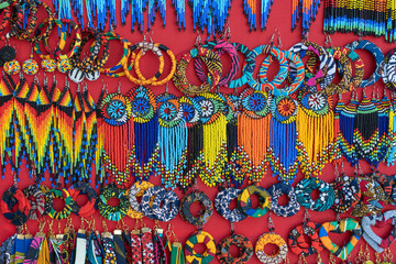 Tribal masai colorful earrings for sale for tourists at the beach market, close up. Island of...