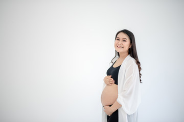 Beautiful young women in the third trimester of pregnancy Pregnant woman holding arms in her...