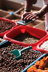 dried fruits and nuts on the counter. A man photographs dried fruits on the phone.