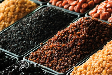 A pile of raisins, various types of dried fruits and other organic products on the counter of the store.