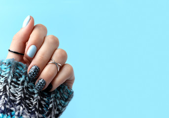 Womans hands with manicure in knitted wool sweater