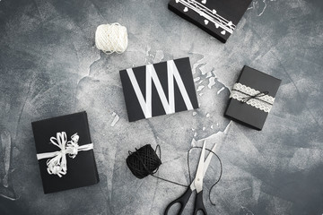 Christmas gifts with scissors and twine on dark. Holiday concept. Flat lay.