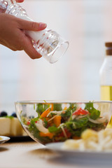 Girl Salts Vegetable Salad, Closeup. Homemade food concept. Family dinner