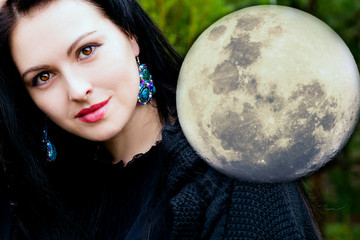 Naklejka premium Beautiful black-haired woman and a big full moon