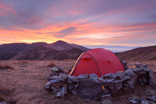 Red tourist tent on autumn mountain range in Romania, Rodna Mountains