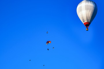 Balloon flies next to parachute . extreme sport . 