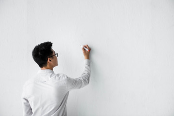 back view of seo manager writing on white wall