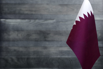 Fragment of the flag of Qatar in the foreground blurred light background copy space