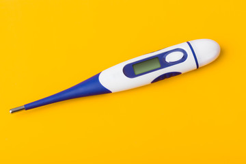 Electronic medical thermometer with blank screen on yellow background