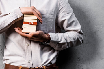 cropped view of seo manager holding wooden rectangles with lettering seo