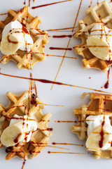 waffles with yogurt syrup and banana top view close-up