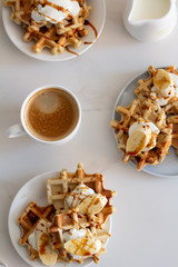 waffles with syrup and coffee for breakfast on a white background