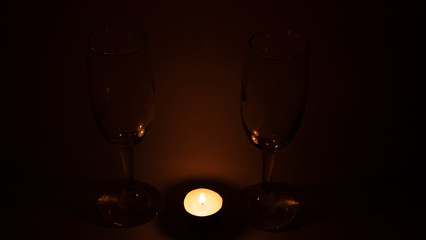 Burning candle near the glasses of champagne, romantic dinner