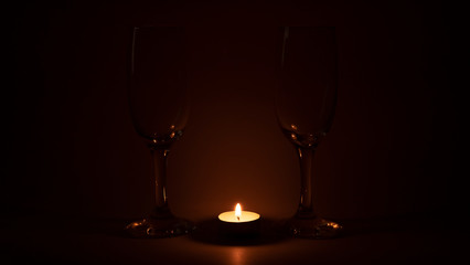 Burning candle near the glasses of champagne, romantic dinner