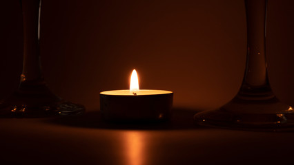 Burning candle near the glasses of champagne, romantic dinner