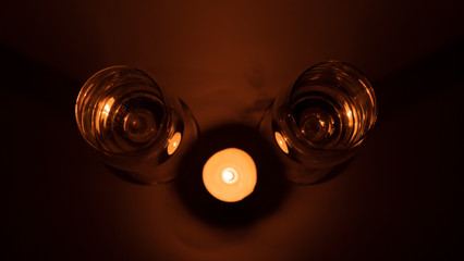 Burning candle near the glasses of champagne, romantic dinner