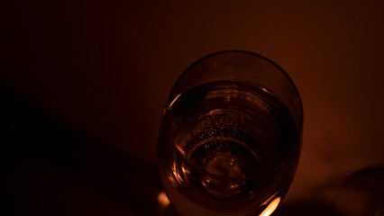 Glass with champagne on a background of candle flame