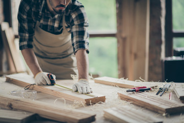 Cropped view of his he nice attractive focused experienced professional guy expert measuring plank board creating house project start-up at modern industrial loft style interior indoors