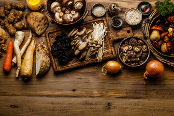 Ingredients for Healing mushroom soup - 7 types of mushrooms and roots on wooden table background copy space for design