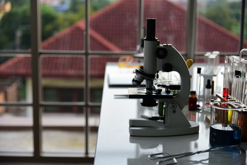 Laboratory Microscope and chemical laboratory glassware beside.