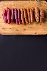 fruit rolls on a wooden board on a black background. Useful sweets. Proper nutrition. Sweet Sugar Free Snacks.
