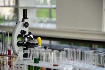 Laboratory Microscope and chemical laboratory glassware blurred on the foreground.
