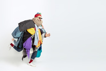 Man addicted of sales, clothes, overproduction and crazy demand. Female model wearing too much colorful clothes, need more things to be happy. Fashion, style, black friday, sale, abusing purchases.