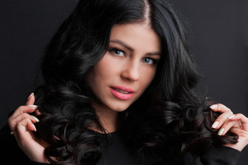 Brunette woman touching curly hair