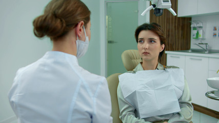 Dentist in mask friendly talks to a girl 