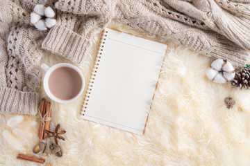 Obraz na płótnie Canvas Autumn or winter composition. Gift box Coffee cup, notebook, anise stars, beige sweater on cream color knitted blanket background. Flat lay top view copy space.