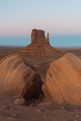 The East Mitten. A portrait view of the eastern mitten behind two rocks at foreground