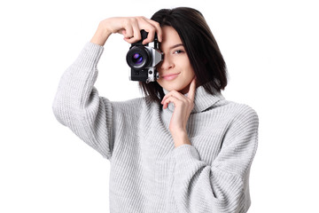 Portrait of a smiling young woman holding retro camera