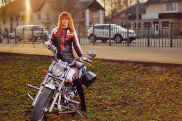Fototapeta na wymiar Tourer motorcycle and woman biker in the autumn city