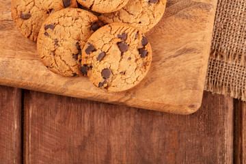 Gluten-free chocolate chip cookies, overhead shot on a dark rustic wooden background with a place for text