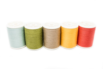 Colored spools of cotton thread isolated on white