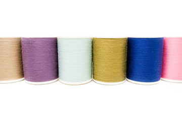 Colored spools of cotton thread isolated on white