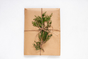 Fototapeta na wymiar Eco gift box wrapping in kraft paper on white background isolated. Vintage eco-friendly natural style. Composition with present decorated with Christmas tree branches. Top view,New year flatlay,mockup